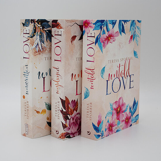 Das Buchcover zeigt … pastellrosanen Hintergrund mit großen pinken und blauen Blüten, blauen Blättern und dem Titel „untold LOVE“ in eleganter Schrift.