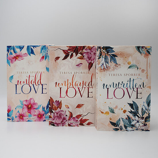 Das Buchcover zeigt drei nebeneinander stehende Bücher mit pastellfarbenen Hintergründen und großen floralen Motiven in Pink Blau und Rosttönen.