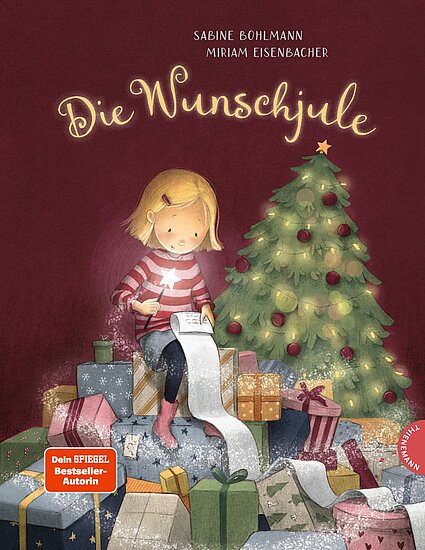 Das Buchcover zeigt … ein blondes Mädchen im rotweiß gestreiften Pullover auf Geschenken mit einer langen Wunschliste und einem grünen Weihnachtsbaum.