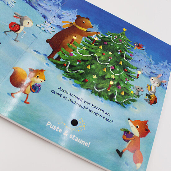 Das Buchcover zeigt einen geschmückten grünen Baum vor blauem Himmel, umgeben von einem braunen Bären mit gelbem Schal, Füchsen und Hasen.
