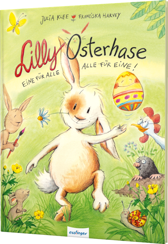 Das Buchcover zeigt den weißen Hasen Lilly, der fröhlich auf einer Wiese mit bunten Blumen steht. Im Hintergrund sind weitere Tiere, darunter ein brauner Hase und ein Vogel, sowie ein bemaltes Osterei zu sehen.