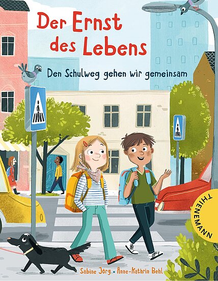Das Buchcover zeigt zwei Kinder auf einem Schulweg, die fröhlich miteinander sprechen. Ein Junge mit braunen Haaren trägt ein grünes T-Shirt, das Mädchen hat blonde Haare und einen gelben Rucksack. Im Hintergrund sind Häuser und Bäume in sanften Farben sowie Vögel zu sehen.