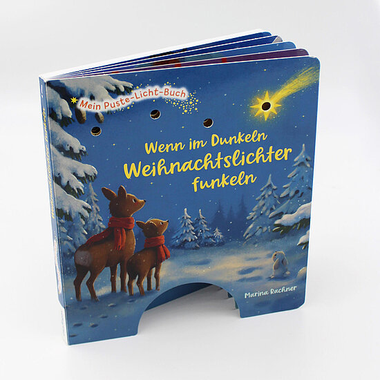 Das Buchcover zeigt ... zwei Rehe mit roten Schals vor verschneiten Tannen und einen leuchtenden Stern am dunkelblauen Nachthimmel.