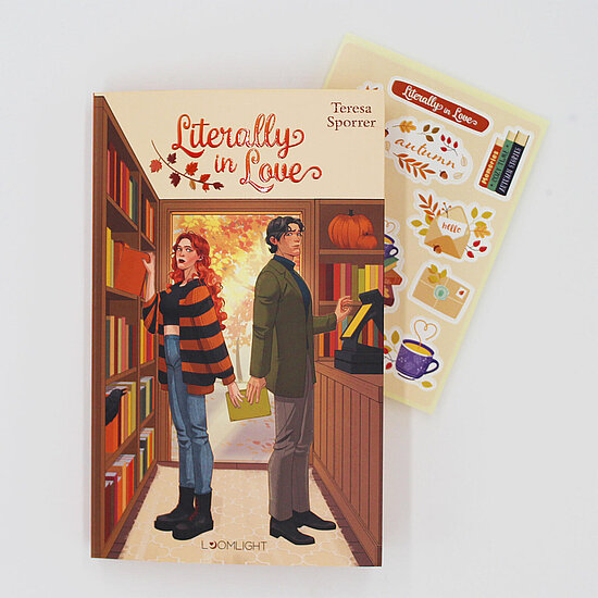 Das Buchcover zeigt zwei Rücken an Rücken in einer herbstlichen Buchhandlung, rothaarige Frau im gestreiften Pullover und Mann im grünen Mantel.