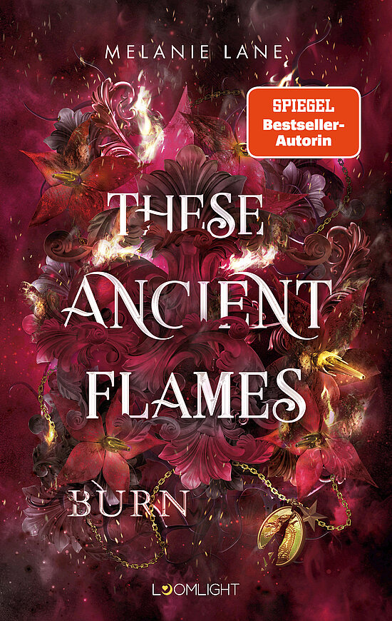 Das Buchcover zeigt einen mystischen Hintergrund in warmen Rottönen, umgeben von lila Blüten und flammenden Elementen. Der Titel „These Ancient Flames Burn“ ist in großen, eleganten Buchstaben platziert.