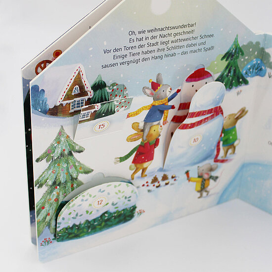 Das Buchcover zeigt … eine winterliche Szene mit bunten Tieren beim Schneemannbauen, Tannenbaum, Lebkuchenhaus und Adventstürchen.