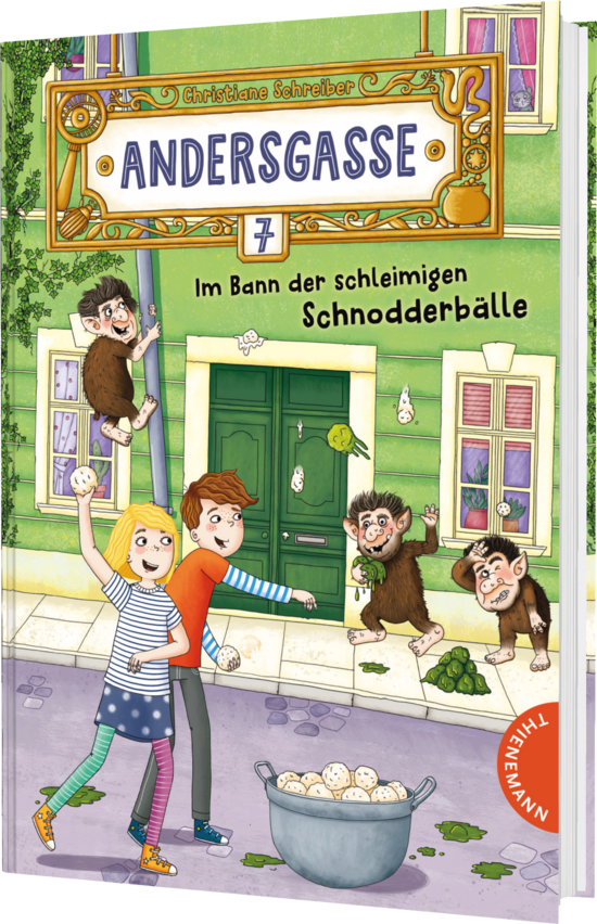 Das Buchcover zeigt eine bunte Straßenszene mit einem grünen Haus. Zwei Kinder, ein Junge mit gestreifter Bluse und ein Mädchen mit roten Haaren, halten Bälle und lachen, während zwei affenähnliche Figuren an der Wand hängen.