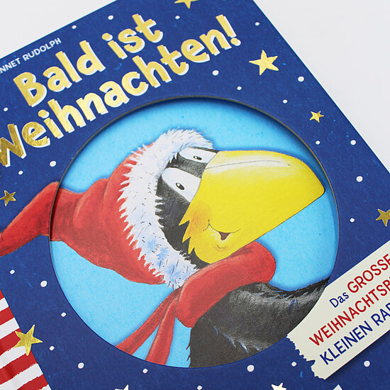 Das Buchcover zeigt einen fröhlichen schwarzen Raben mit gelbem Schnabel in roter Weihnachtsmütze und rotem Schal vor blauem Sternenhimmel.