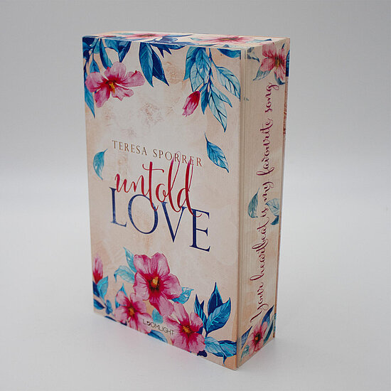 Das Buchcover zeigt ... auf beigefarbenem Hintergrund pinke Blüten und blaue Blätter um den Schriftzug untold LOVE und Autorennamen.