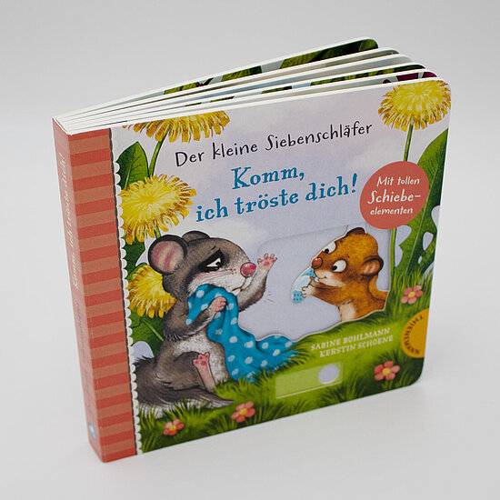 Das Buchcover zeigt zwei kleine Siebenschlaefer, einen grauen mit blauem Tuch und einen braunen, umgeben von gelben Loewenzahn und gruenem Gras.