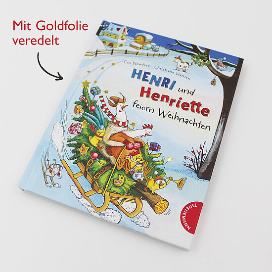 Das Buchcover zeigt … zwei Tierfiguren Henri und Henriette auf einem Schlitten mit geschmücktem Tannenbaum und bunten Geschenken vor blauem Himmel.