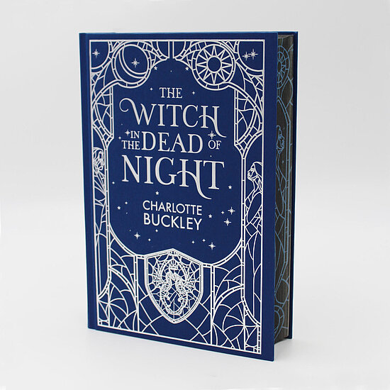 Das Buchcover zeigt ein dunkelblaues Feld mit weißem filigranen Rahmen, Sternen, Mondsichel und Sonnenmotiv sowie ornamentalem Wappen.