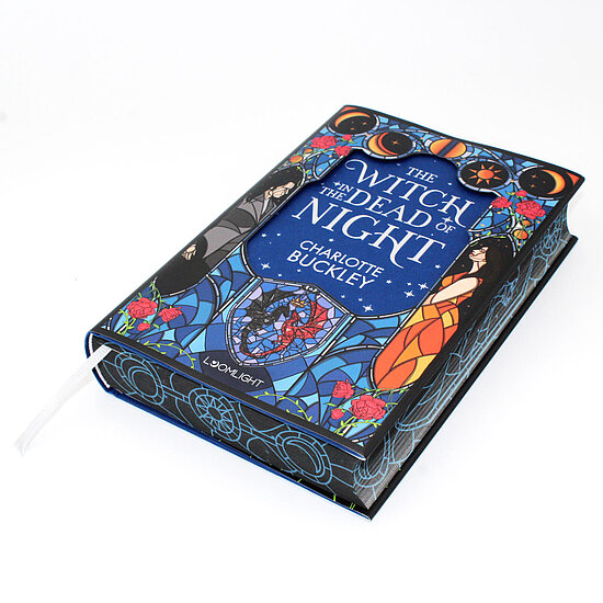 Das Buchcover zeigt blauen Glasfensterstil links einen dunkel gekleideten Mann und rechts eine Frau im orangefarbenen Kleid mit Rosen und Mondphasen.