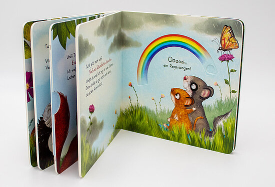 Das Buchcover zeigt zwei kuschelige Tierkinder, ein orangefarbenes und ein graues, auf grüner Wiese unter Regenbogen und Schmetterling.