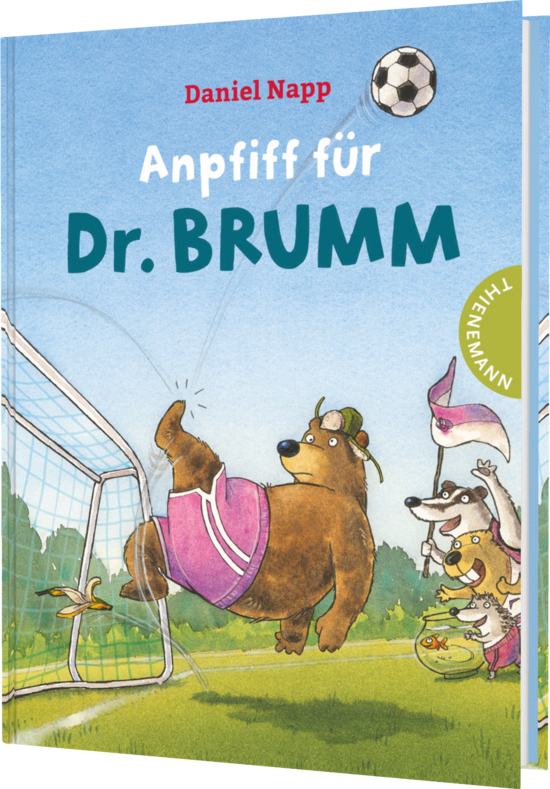 Das Buchcover zeigt einen großen, braunen Bären in pinken Shorts, der im Fußballtor steht. Um ihn herum sind fröhliche Tiere, darunter ein Hund und ein kleines Tier, die aktiv Fußball spielen. Der Himmel ist hellblau mit einer Wolke und einem fliegenden Fußball.