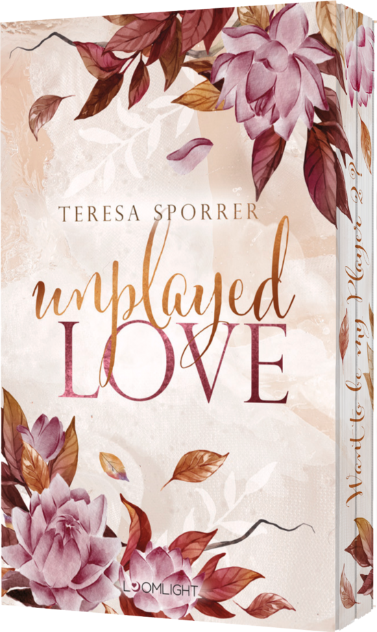 Das Buchcover zeigt einen sanften Hintergrund in Rosa- und Beigetönen, umrahmt von zarten, blühenden Blumen in Lila und Gold. Der Titel „unplayed LOVE“ ist elegant in geschwungener Schrift dargestellt.