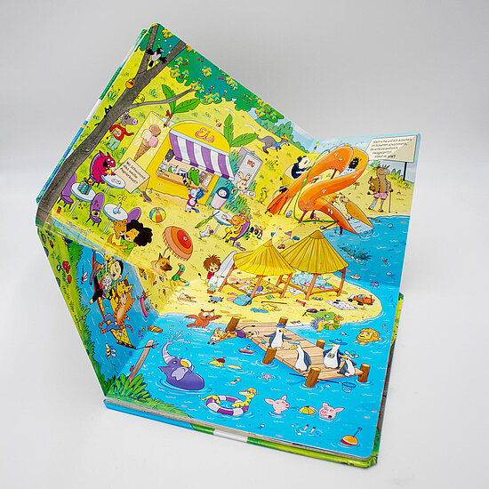 Das Buchcover zeigt eine bunte Strandparty mit spielenden Kindern und Tieren, gelbem Sand, blauem Meer, oranger Rutschbahn, Strohhuetten und Eisstand.