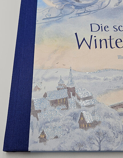 Das Buchcover zeigt eine sanfte Winterlandschaft mit verschneiten Dächern und Bäumen in Blau-, Grau- und Pastelltönen sowie funkelnden Schneereflektionen.